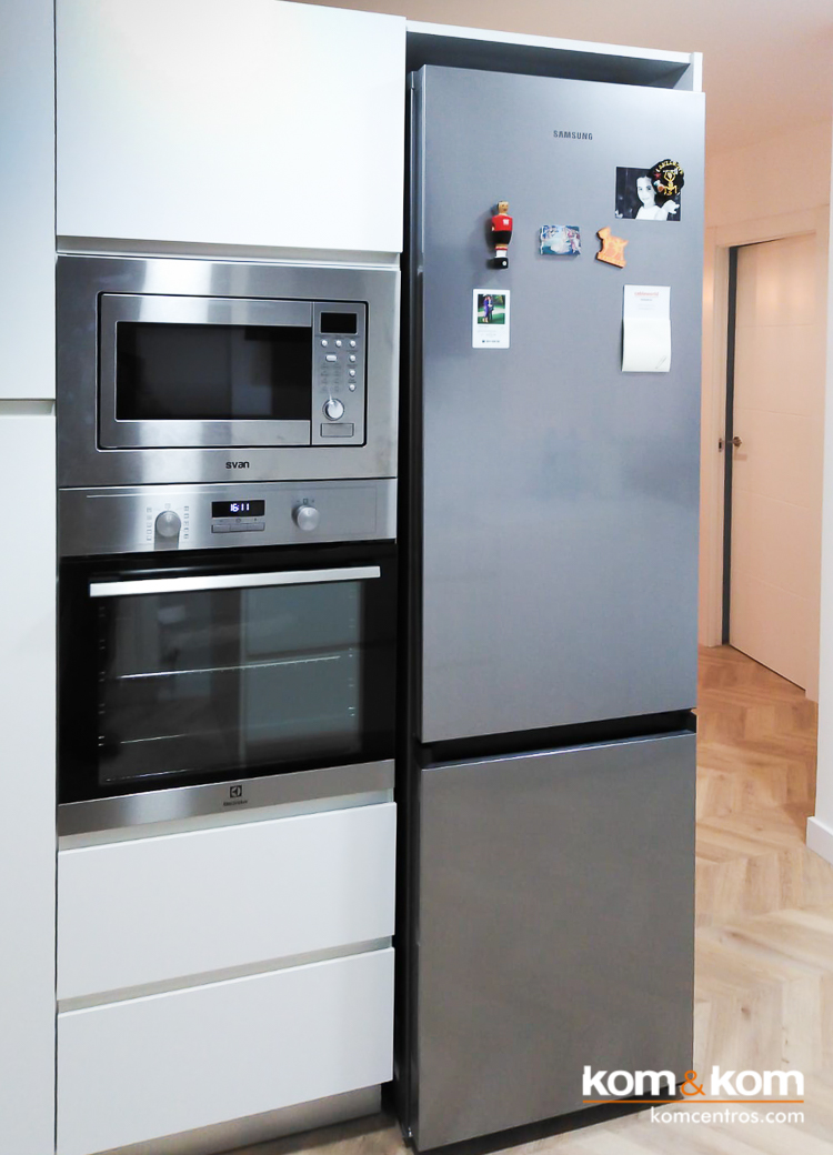 Microondas, horno y frigor&iacute;fico Inox integrados en mueble blanco en cocina moderna abierta al sal&oacute;n